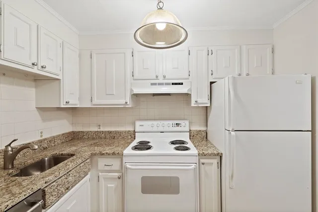 a kitchen with a stove a refrigerator and a sink