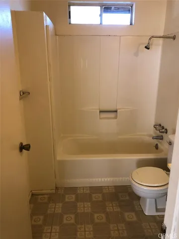 a bathroom with a granite countertop toilet a sink and shower