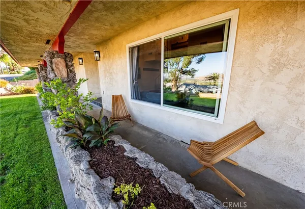 a view of a two chair in the patio with potted plants