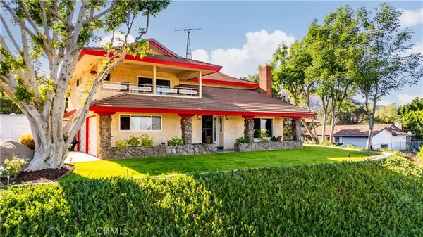 a view of a house with a big yard and potted plants