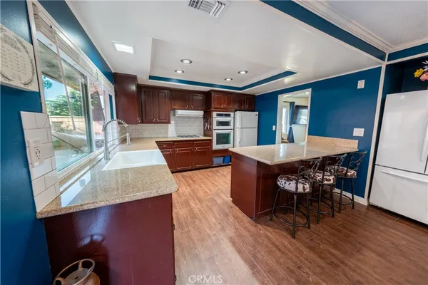 a living room with dining table wooden floor and a large window