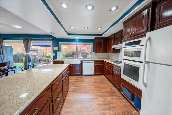 a large kitchen with stainless steel appliances granite countertop a large counter top a stove and a sink