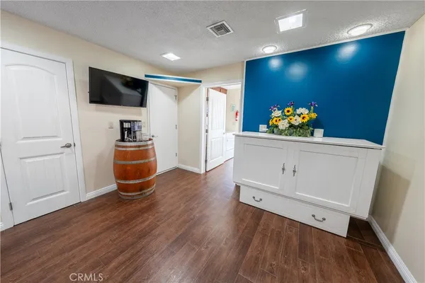 a view of a livingroom with wooden floor and furniture