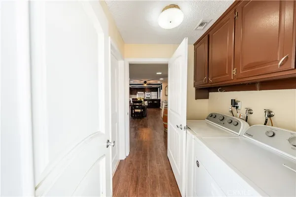 a hallway with a view of bedroom with wooden floor