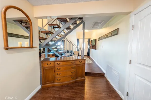 a view of entryway and hall with wooden floor