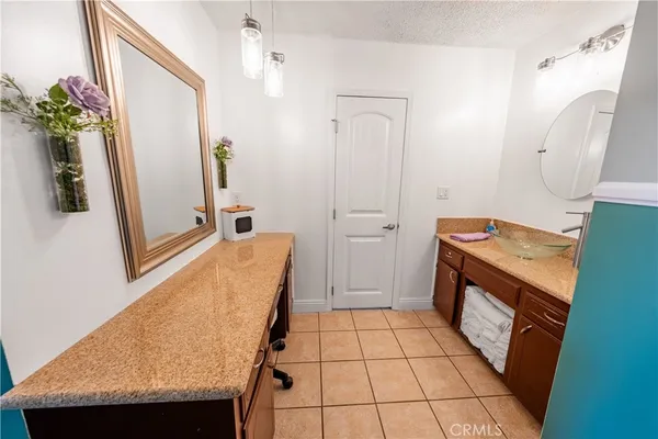 a bathroom with a granite countertop sink and a mirror