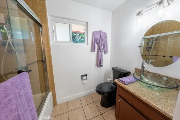 a bathroom with a granite countertop bathtub sink and toilet
