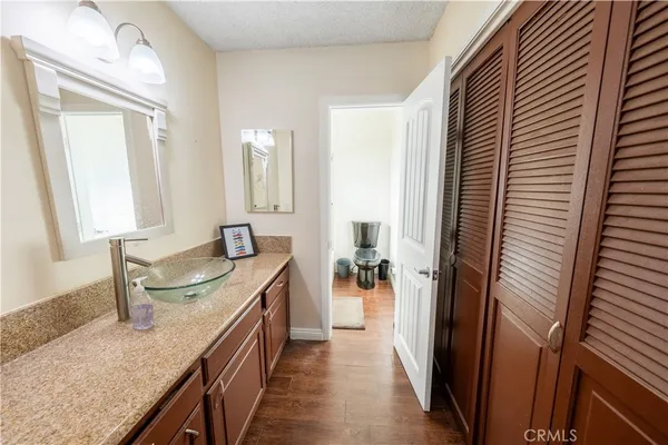a en suite bathroom with a granite countertop sink and a mirror