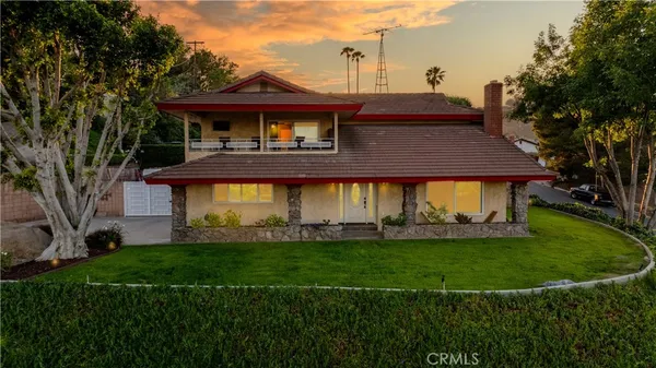 a front view of a house with a garden and yard