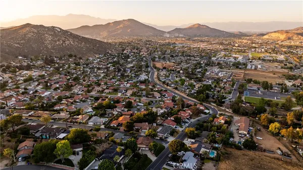 an aerial view of residential houses with outdoor space and trees