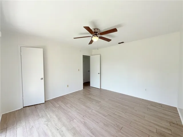 a view of a big room with wooden floor and a ceiling fan