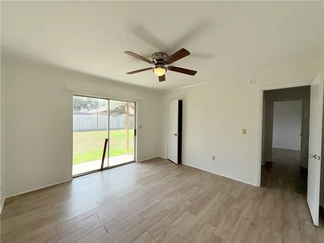 an empty room with fan and windows