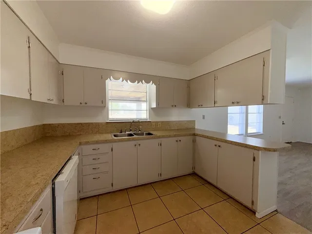 a kitchen with cabinets appliances a sink and a window