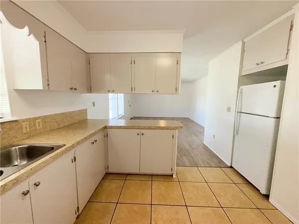 a kitchen with a sink a refrigerator and cabinets