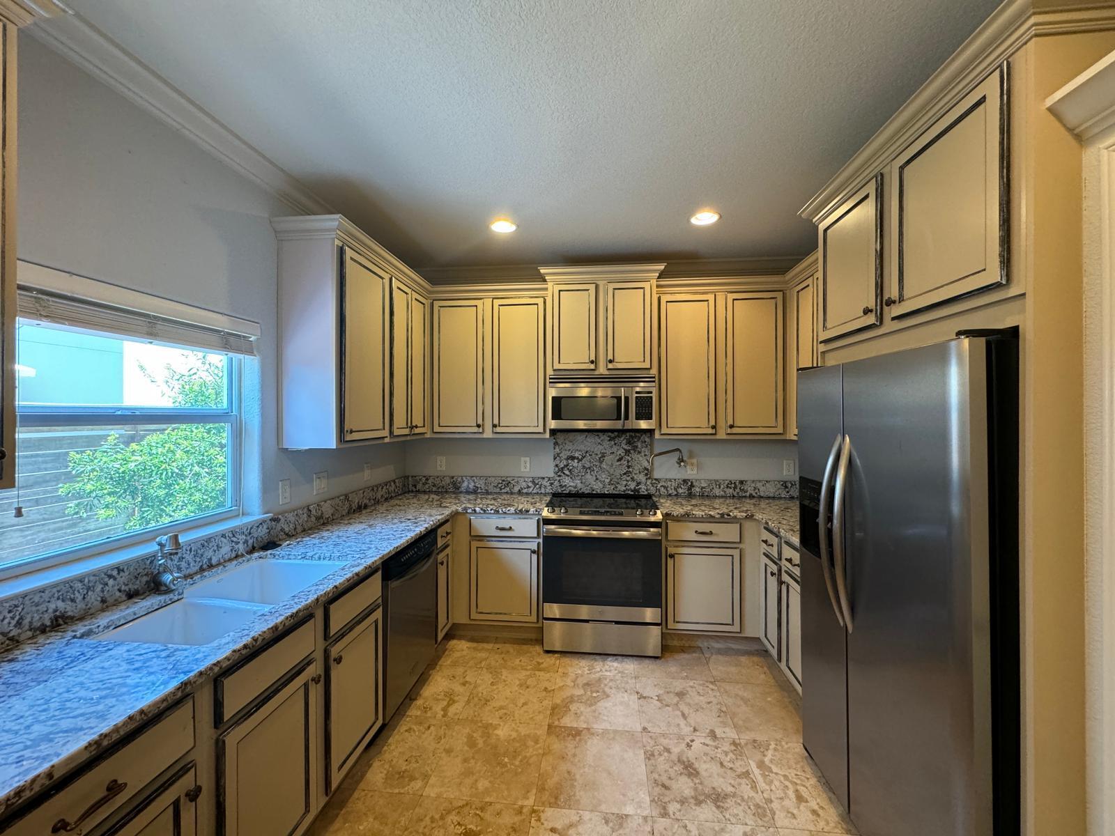 241 Inverrary Drive Destin, FL 32541 - Photo 6 of 24 a kitchen with stainless steel appliances granite countertop sink stove refrigerator and cabinets