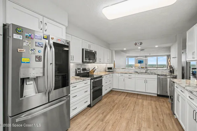 a kitchen with white cabinets and stainless steel appliances