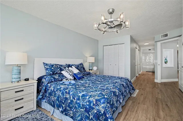 a bedroom with a large bed and a chandelier