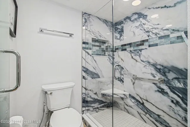 a bathroom with a granite countertop toilet sink and shower