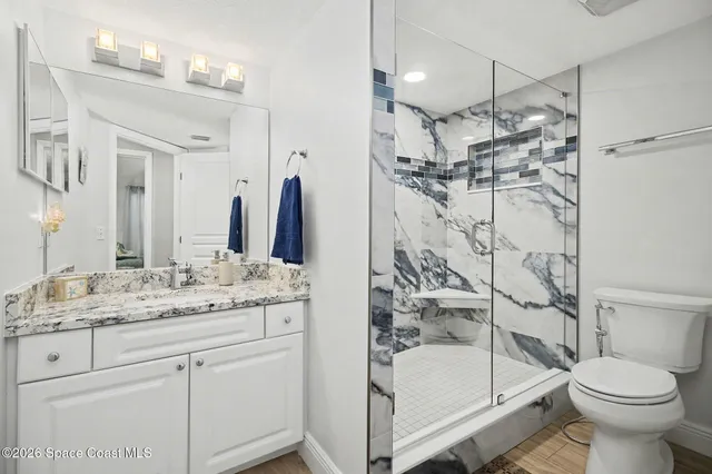 a bathroom with a sink toilet double vanity and shower
