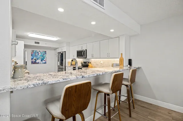 a view of kitchen with granite countertop cabinets table and chairs