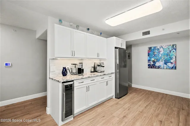 a kitchen with stainless steel appliances white cabinets and wooden floor