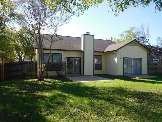 an empty room with wooden floor fireplace and windows