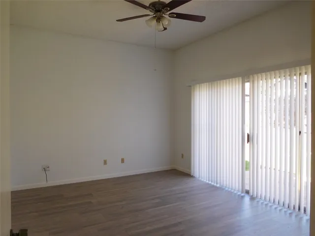 a view of a room with wooden floor and fan