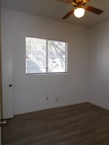 a view of empty room with wooden floor and fireplace