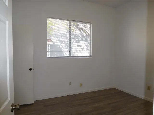a kitchen with a sink stove top oven and wooden floor