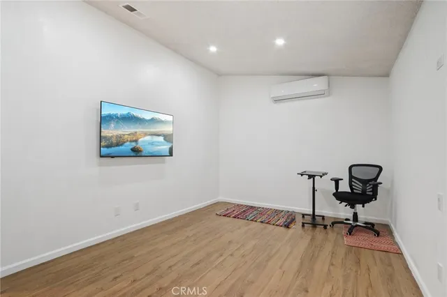 a view of room with a wooden floor and a workspace