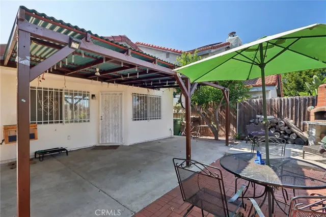 a patio with a table and chairs under an umbrella