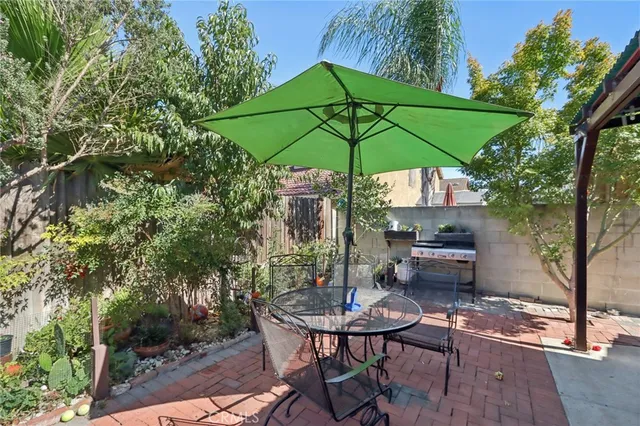 a view of a backyard with a patio table and chairs under an umbrella