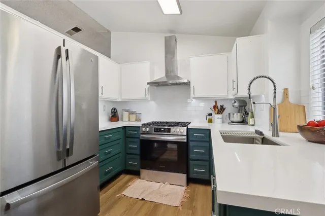 a kitchen with stainless steel appliances a stove a refrigerator and a sink