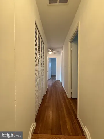 a view of a hallway with wooden floor and staircase