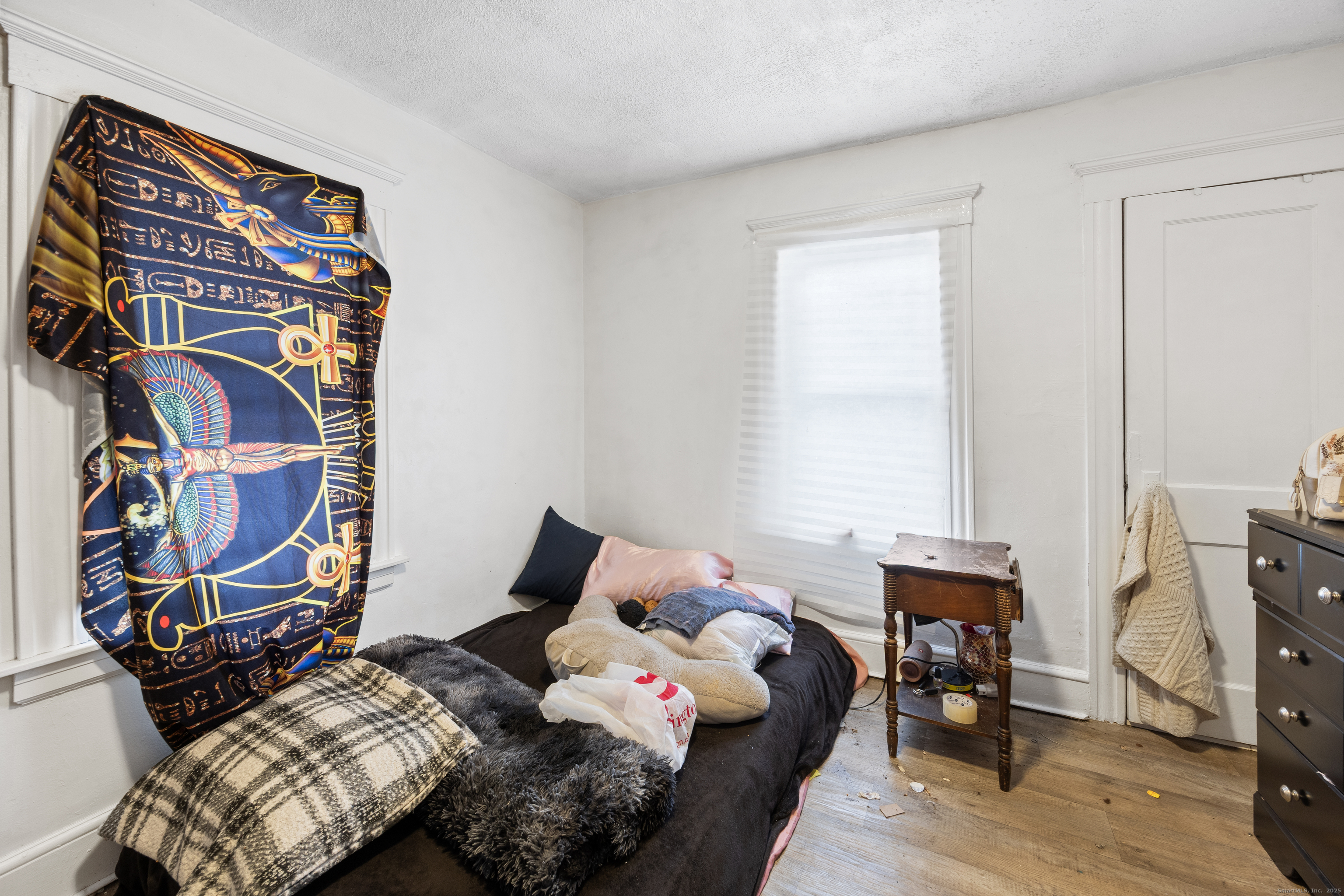 29 Berry Street Torrington, CT 06790 - Photo 19 of 31 a bedroom with a bed and a lamp on dresser with wooden floor