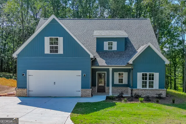 a view of a house with a yard chairs and table