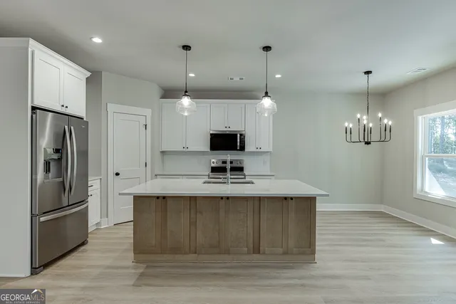 a view of a kitchen with a sink stainless steel appliances and cabinets