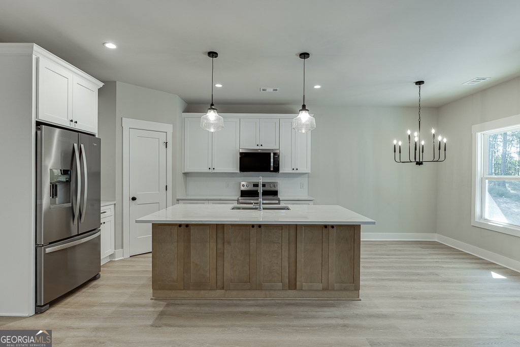 110 Rains Road Jefferson, GA 30549 - Photo 12 of 43 a view of a kitchen with a sink stainless steel appliances and cabinets