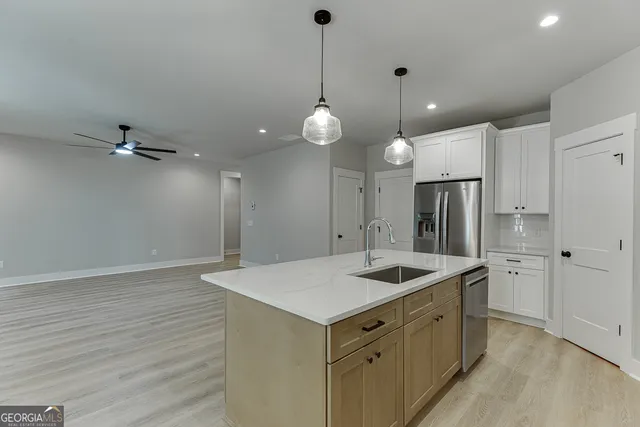 a kitchen with a sink chandelier and refrigerator