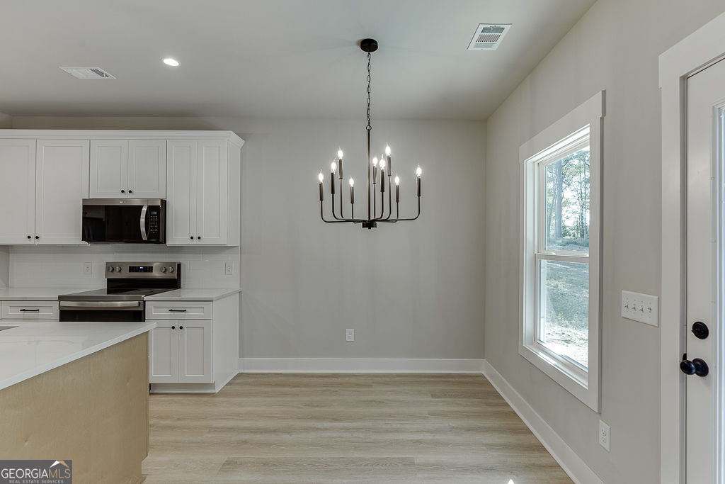 110 Rains Road Jefferson, GA 30549 - Photo 18 of 43 a kitchen with stainless steel appliances granite countertop a refrigerator a sink dishwasher a stove and white cabinets with wooden floor