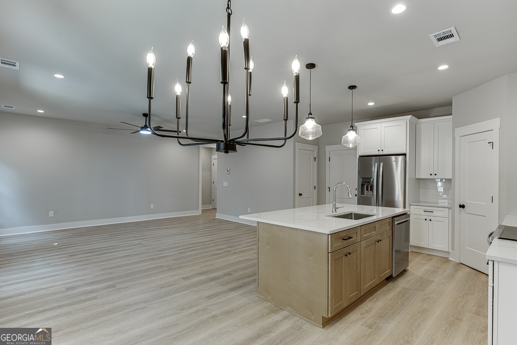 110 Rains Road Jefferson, GA 30549 - Photo 19 of 43 a kitchen with a sink chandelier and refrigerator