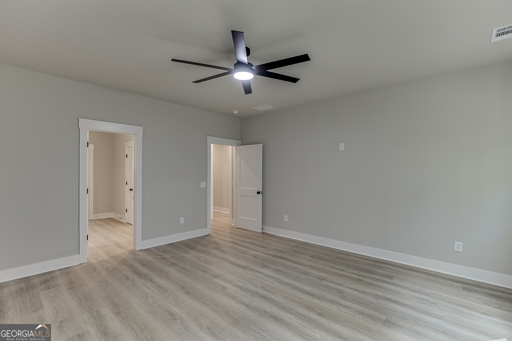 110 Rains Road Jefferson, GA 30549 - Photo 23 of 43 an empty room with wooden floor a ceiling fan and windows