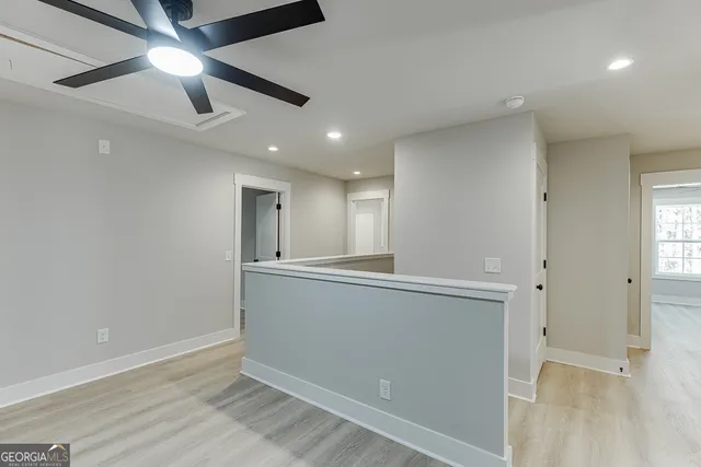 a view of an empty room with window and wooden floor