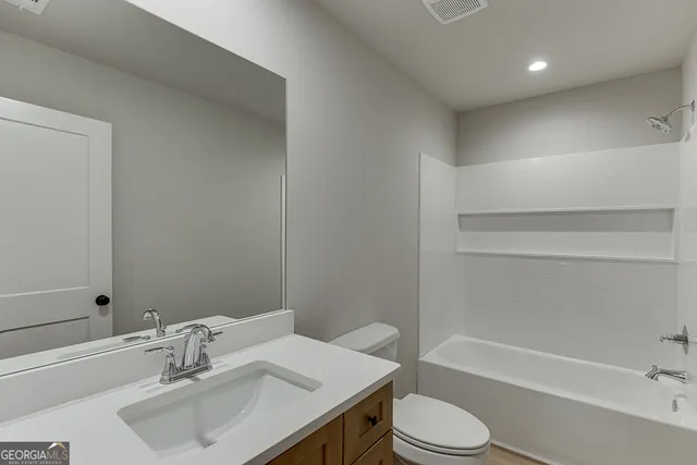 a bathroom with a sink toilet vanity and bathtub