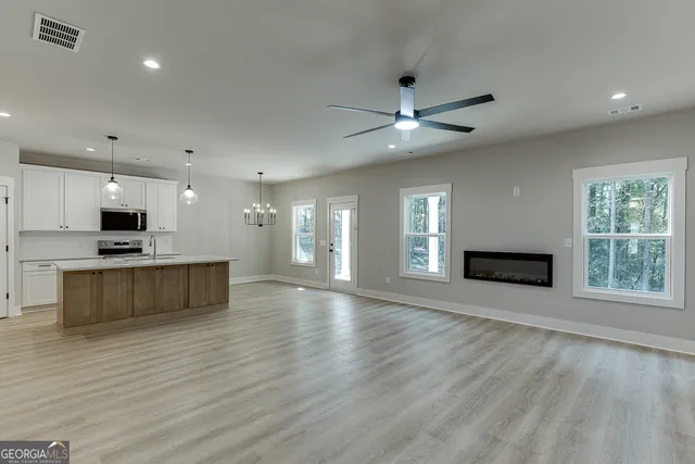a view of kitchen with microwave and stove top oven