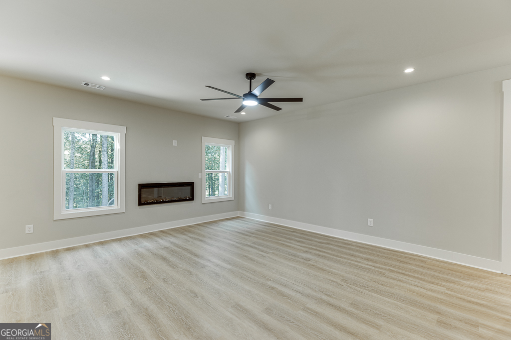110 Rains Road Jefferson, GA 30549 - Photo 9 of 43 an empty room with ceiling fan and windows