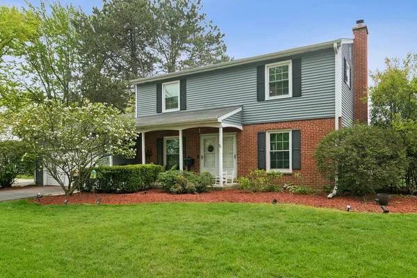 a front view of a house with a yard and plants