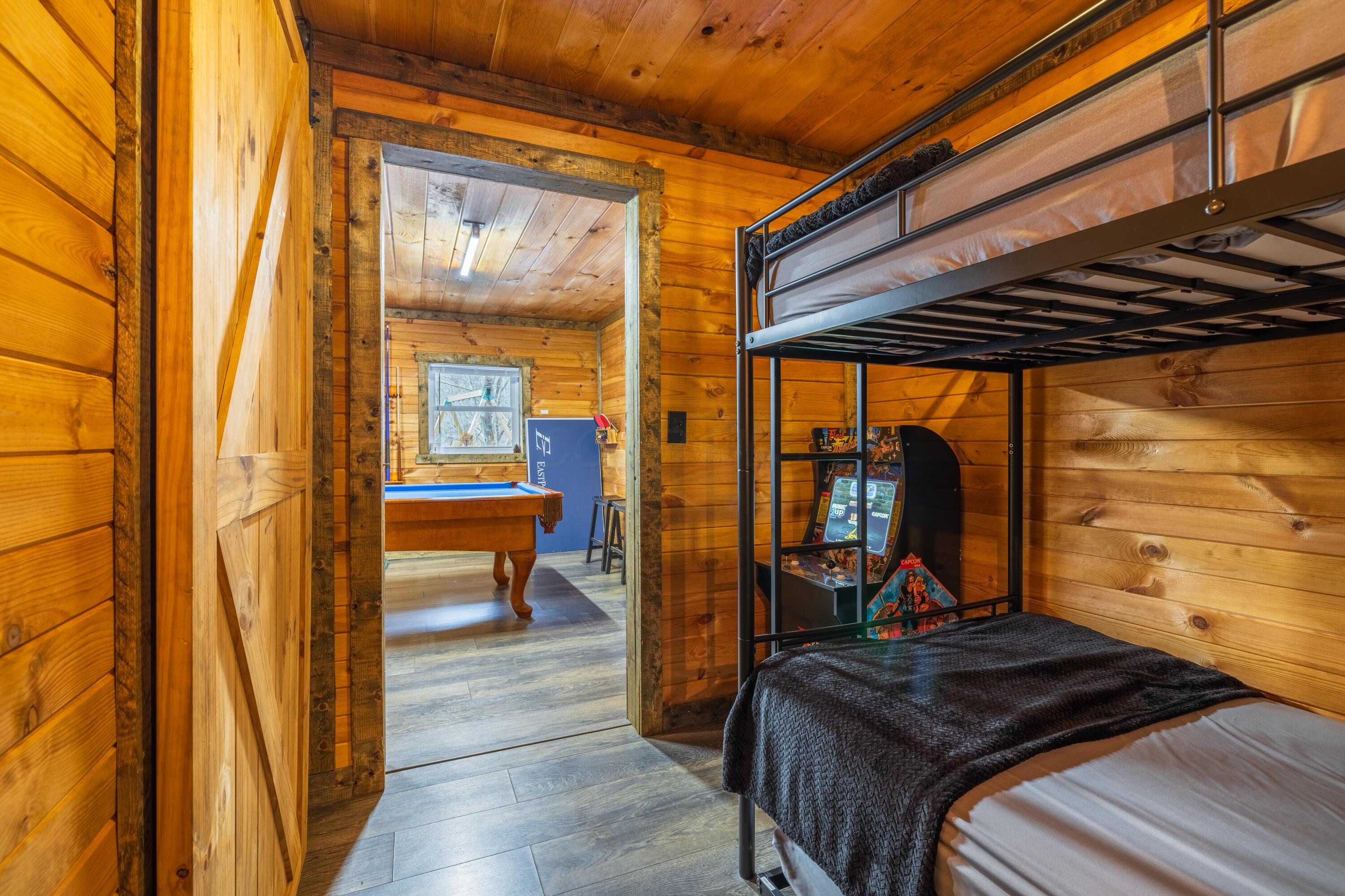 344 Skaggs Road Londonderry, OH 45647 - Photo 43 of 57 Sage Hill Cabin bunk room with 2 beds and an arcade game