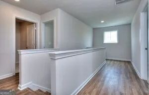 a view of hallway with window and wooden floor