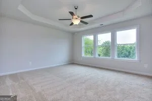 an empty room with a window and a ceiling fan